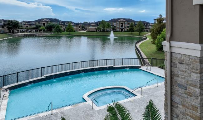 a pool with a body of water and a fountain near it