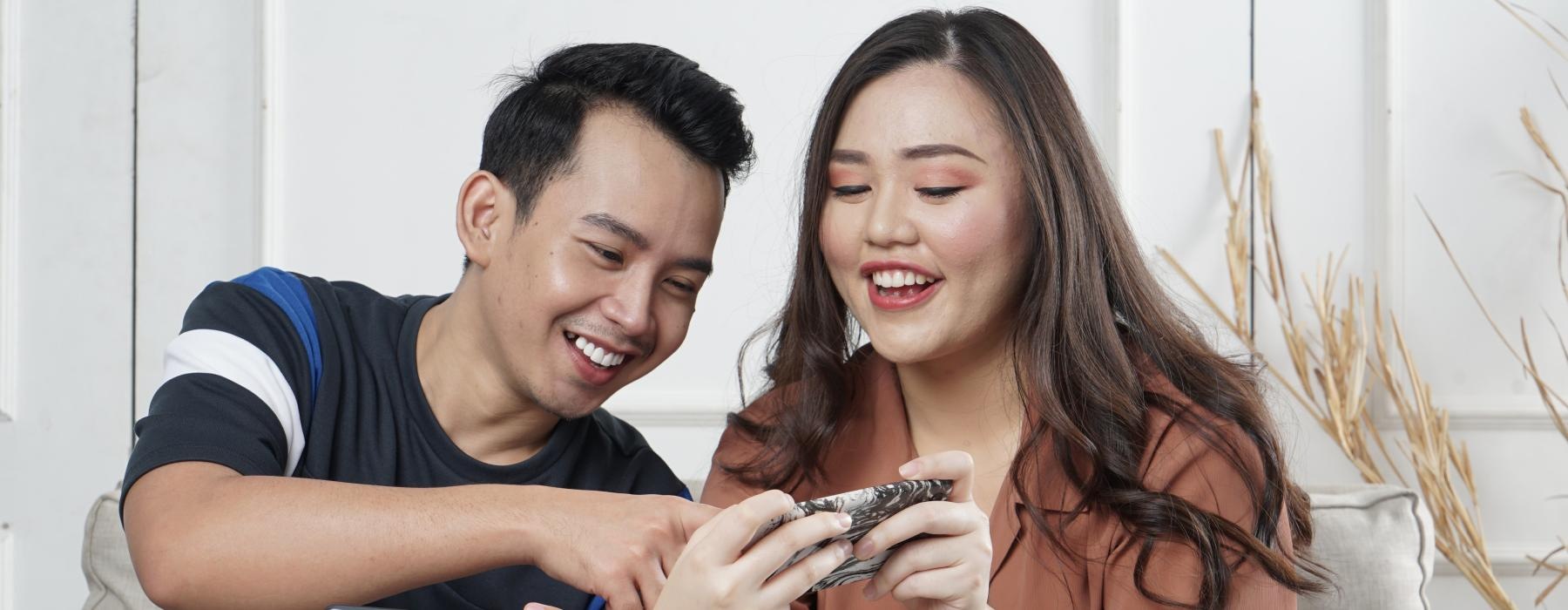 a man and woman looking at their phones