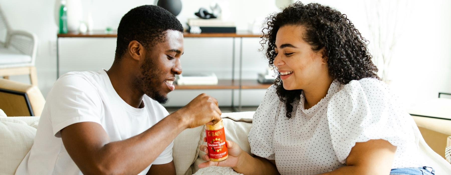 a man and a woman sitting on a couch and eating