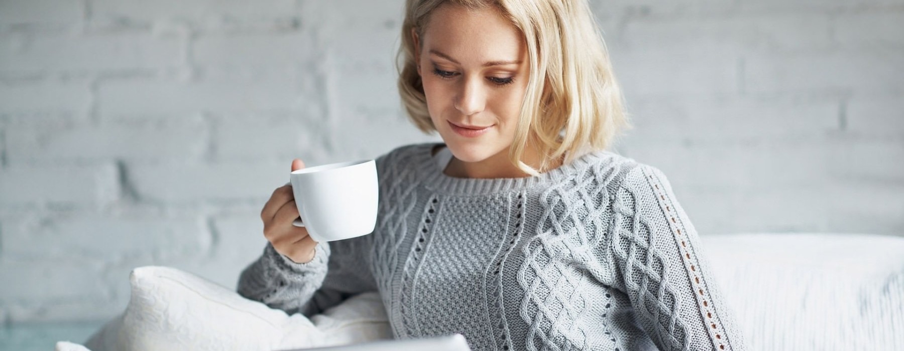 woman on couch with a cup of coffee