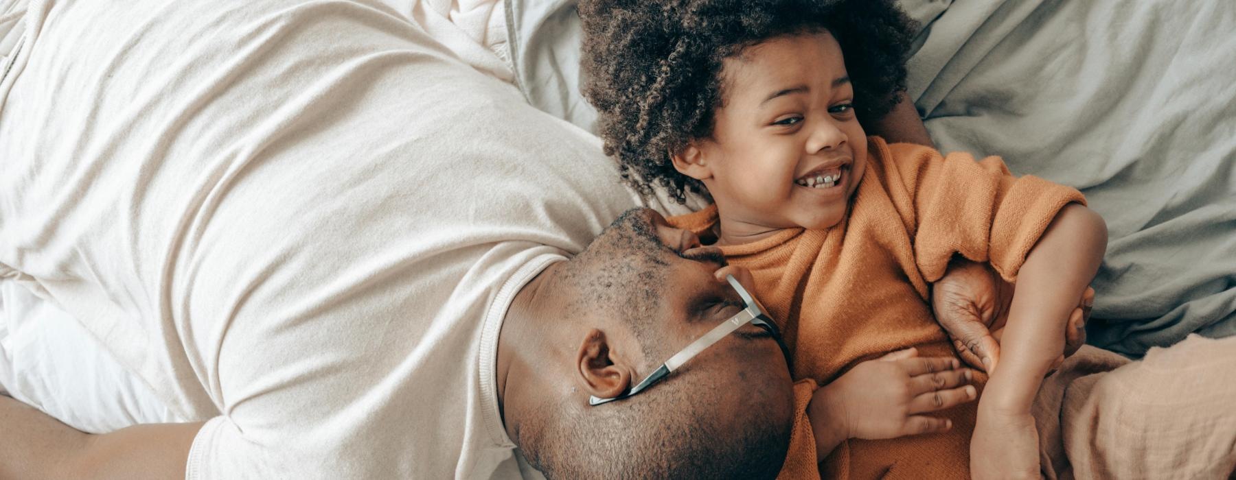 a person and a child lying in bed