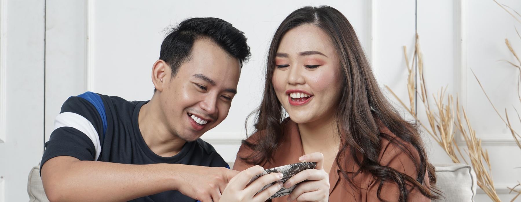 a man and woman looking at their phones