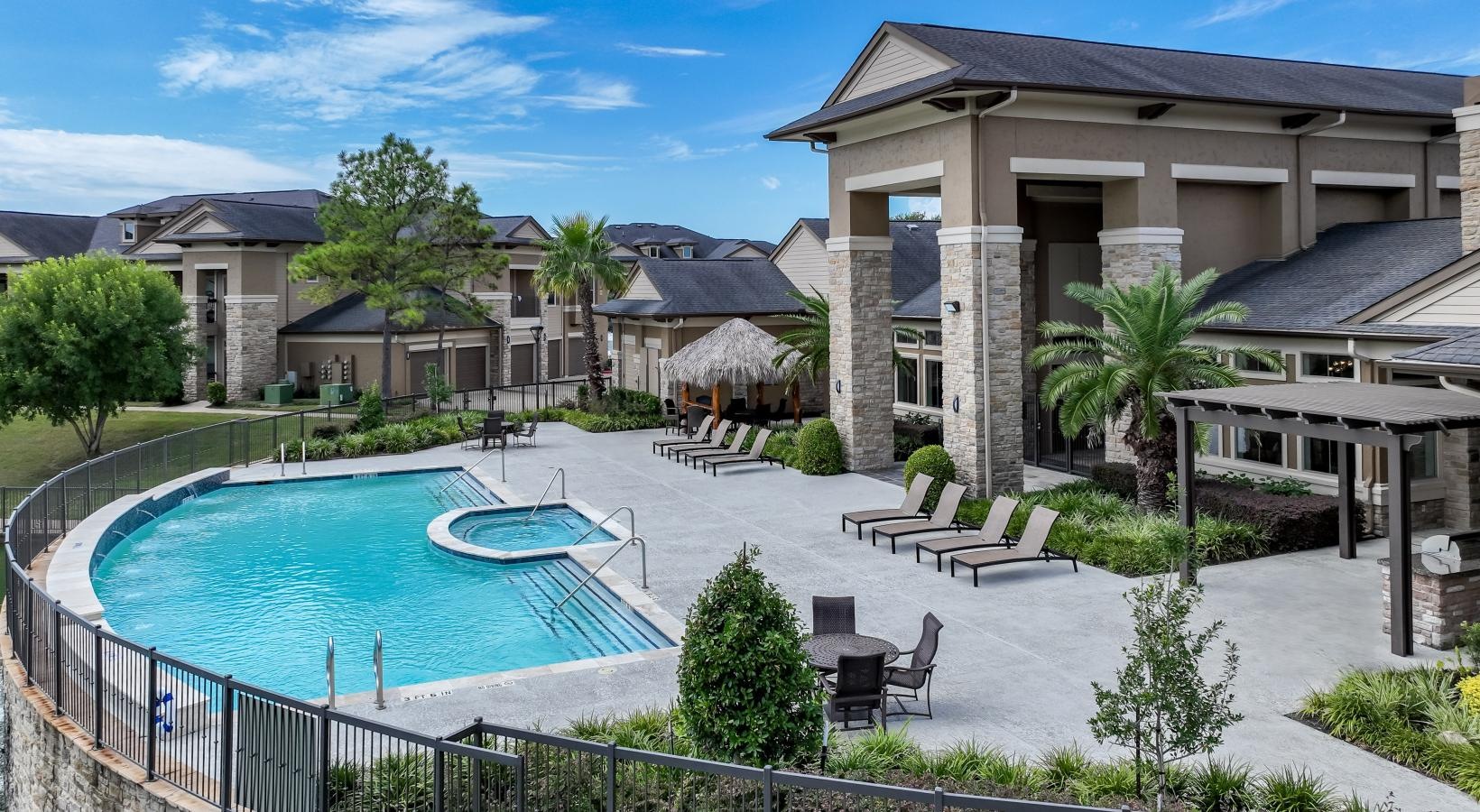 Settle into comfort at The Falls at Copper Lake a pool with lush landscaping